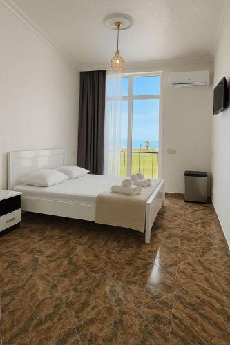 a bedroom with a large bed and a large window at Hotel Georgia in Gonio