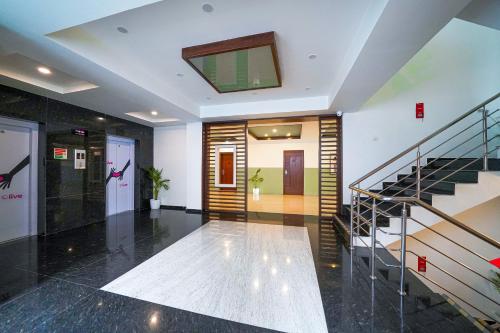 a lobby with a staircase and a stair case at Olive Hotel Electronic City by Embassy Group in Bengaluru