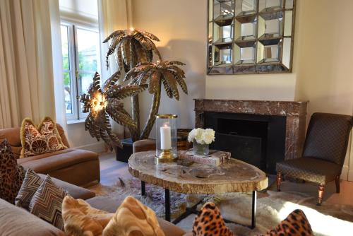 a living room with a table and a fireplace at Hotel Van Cleef in Bruges