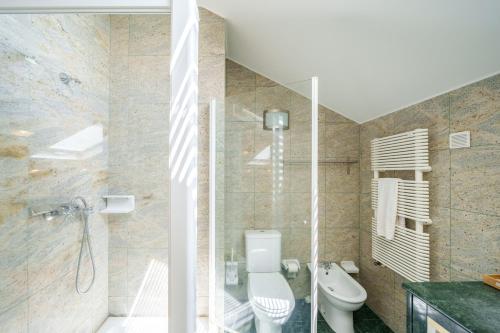 a bathroom with a toilet and a glass shower at Feel Discovery Casa Da Capela Douro Valley in Armamar