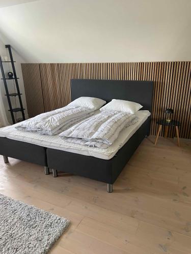 a bed with a black bed frame in a bedroom at Luxury Country House In Nature With Wellness in Haderslev