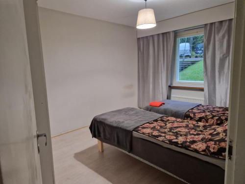 a bedroom with two beds and a window at LibO-apartment, Myllymäki 19 X in Lahti