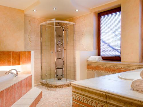 La salle de bains est pourvue d'une douche, d'un lavabo et d'une baignoire. dans l'établissement Sopocki Dwór Apartments, à Sopot