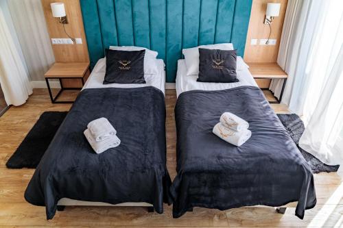 two beds in a room with towels on them at Luksusowe Apartamenty Echo in Cedzyna