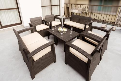 a group of chairs and tables on a patio at YokaYado Kagoshima Chuo - Retro Style Japanese Modern Entire House with Rooftop Balcony in Kagoshima