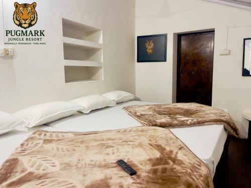 two beds in a room with a tiger sign on the wall at Pug Mark Jungle Resort - Masinagudi in Masinagudi