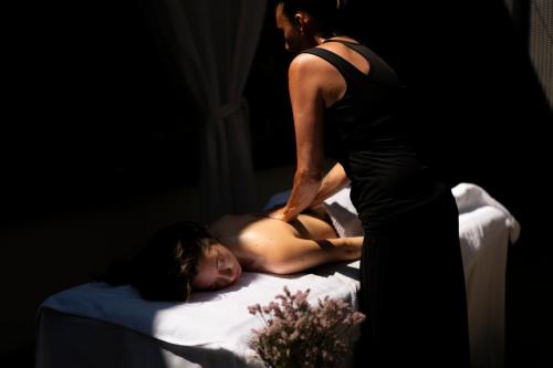 a woman standing next to a girl laying on a bed at VERSOVERDE HOTEL Alzaia Naviglio Grande in Milan