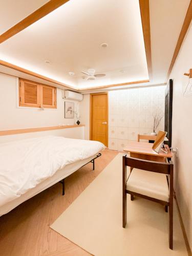 a bedroom with a bed and a desk and a table at Stay 42 Dongmyo in Seoul