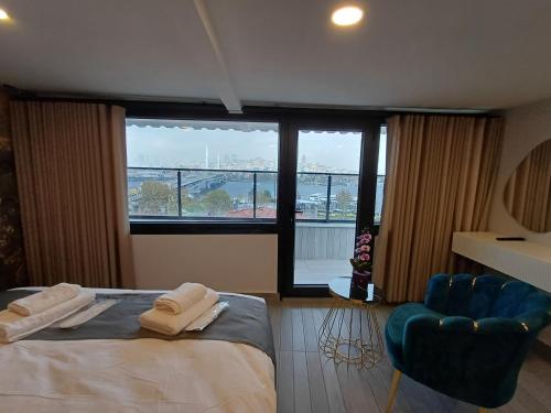 a bedroom with a bed and a chair and a large window at White Palace Haliç in Istanbul