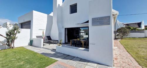 ストロイスバーイにあるAmia House Struisbaaiの庭のテーブル付白い家