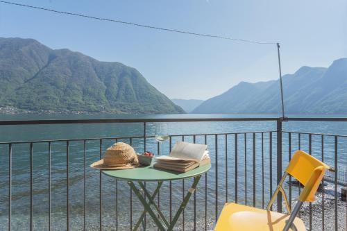 a table with a hat and books on a balcony at Il Timone by Rent All Como in Colonno