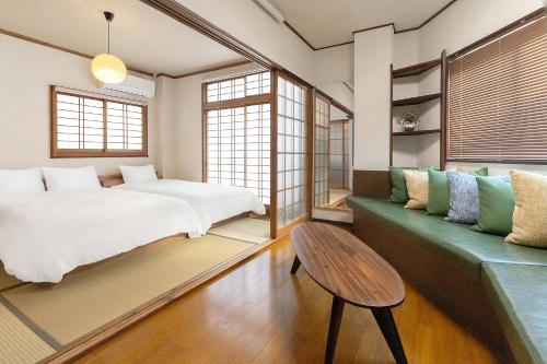 a bedroom with a bed and a green couch at YokaYado Kagoshima Chuo - Retro Style Japanese Modern Entire House with Rooftop Balcony in Kagoshima