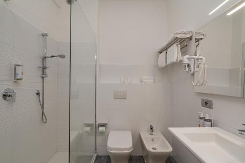 a bathroom with a toilet and a sink and a shower at Hotel Calabona in Alghero