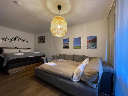 una sala de estar con un sofá y una cama en Modern eingerichtete Ferienwohnung Traumtagerl ruhig, zentral, ideal für Familien & Paare, en Bad Tölz