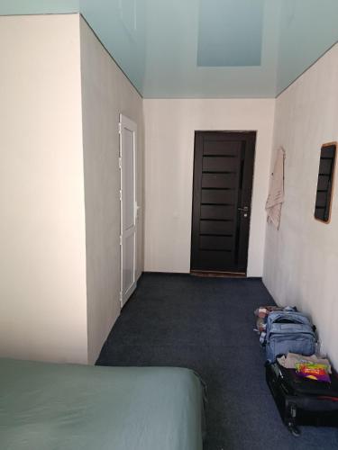 an empty room with a bed and a door at Asian Guest House in Bishkek