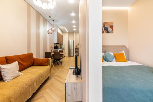a living room with a couch and a bed at Комфортабельная квартира в ЖК Meridian Apartments in Almaty