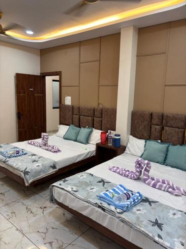 two beds in a room with purple pillows on them at Hotel shree Gajanand palace in Ujjain