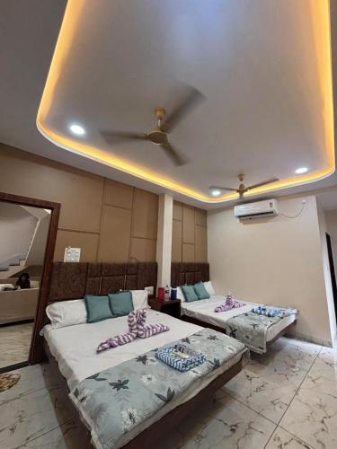 two beds in a room with a ceiling at Hotel shree Gajanand palace in Ujjain