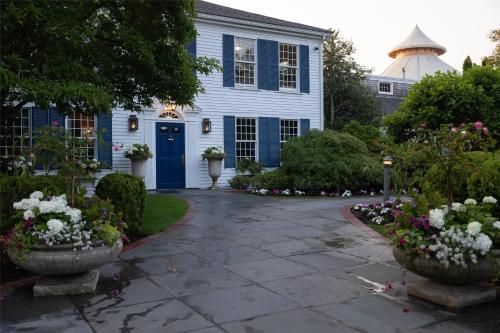a blue house with a blue door and some flowers at Wequassett Resort and Golf Club in East Harwich