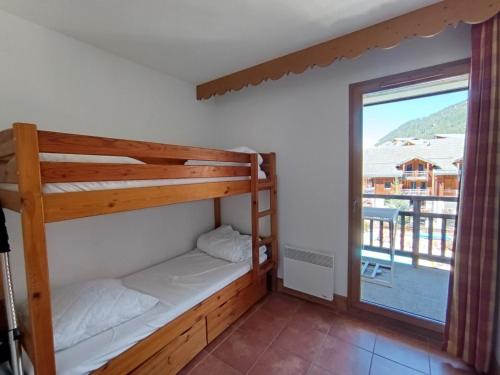 a bedroom with two bunk beds and a large window at Superbe duplex avec garage - Ski aux pieds - FR-1-445-186 in Montgenèvre