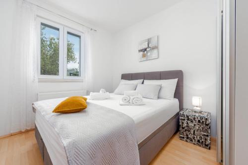 a white bedroom with a bed and a window at Villa Štrkalj ZadarVillas in Murvica
