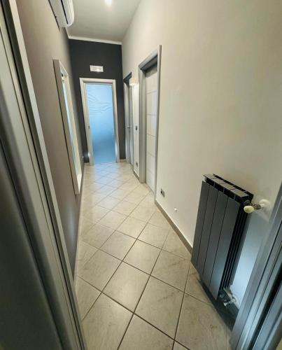 a hallway with a tile floor and a hallway with doors at Scaletta B&B in Crispiano