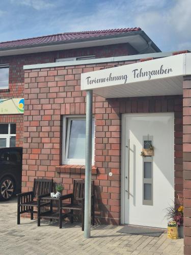 a brick building with two benches in front of it at Ferienwohnung Fehnzauber, 86005 in Ostrhauderfehn