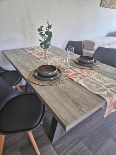 a wooden table with plates and glasses on it at Ferienwohnung Fehnzauber, 86005 in Ostrhauderfehn