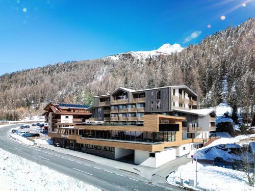 a building in the snow with a mountain in the background at Das Liebener - new opening in December 2025 in Obergurgl