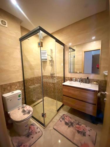 a bathroom with a shower and a toilet and a sink at Superbe appartement à bouznika avec vue sur piscine et jardin privatif in Bouznika