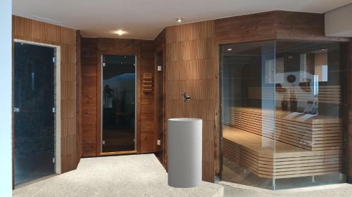 a bathroom with wooden walls and a glass door at Das Liebener - new opening in December 2025 in Obergurgl