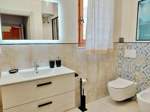 a bathroom with a sink and a toilet and a mirror at Appartamento a due passi da Maria Pia in Alghero