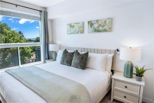 a white bedroom with a bed and a window at Sugarhouse! Mountain View 3BR, 2BA Gym, Parking in Salt Lake City