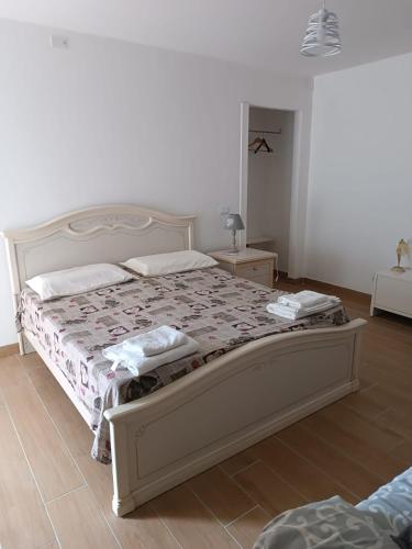 a bedroom with a large bed with a white bed frame at OASI FELIZ Minturno in Minturno
