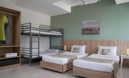 a bedroom with two beds and a bunk bed at Paprika Stays Panjim Donapaula in Panaji