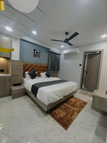 a bedroom with a large bed and a ceiling fan at Hotel Grand Lake in Ahmedabad