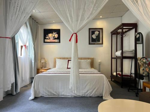 a bedroom with a white bed with a red bow on it at Tropical Garden Phu Quoc in Phu Quoc