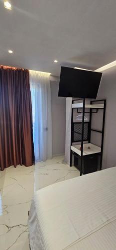 a bedroom with a white bed and a window at Saranda's Crown in Sarandë