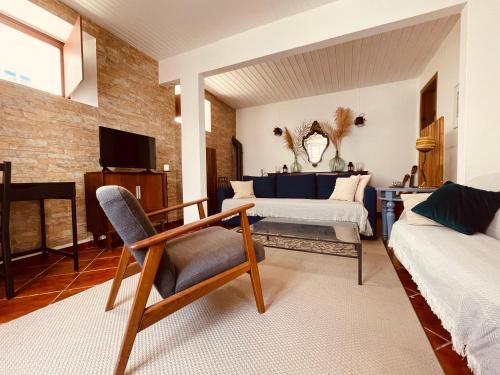a living room with a chair and a couch at La Casa Flores, maison traditionnelle portugaise in Odeceixe
