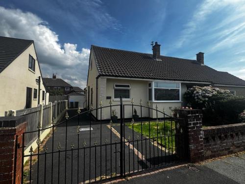 a black fence in front of a house at Chic 2-Bed Loft Bungalow, Cleveleys, Near Beach in Blackpool