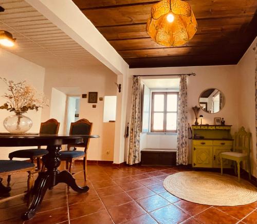 a living room with a table and chairs and a window at La Casa Flores, maison traditionnelle portugaise in Odeceixe