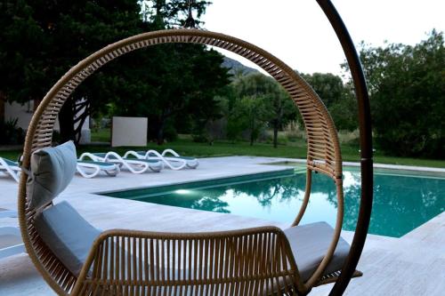 a wicker chair sitting next to a swimming pool at Can Curt Villa in Pollença