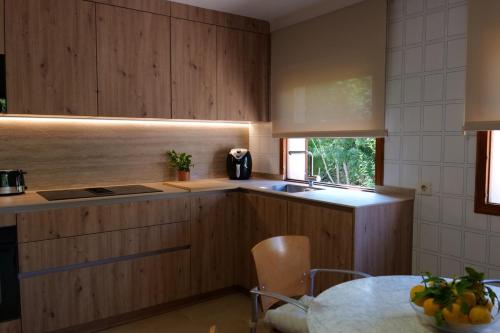 a kitchen with wooden cabinets and a table and a window at Can Curt Villa in Pollença