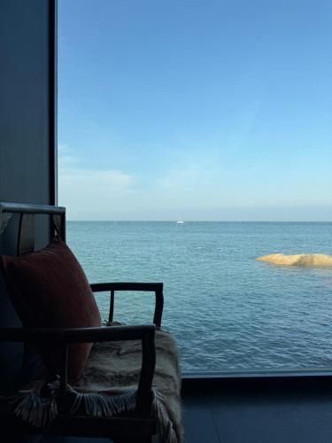 a chair in a room with a view of the ocean at Moya Resort Hotel-Near Laoshan Scenic Area,Free Private Beachcombing, Free DIY Experience, 3 Free Photographers' Photos, Paid provision Featured Seafood in Qingdao
