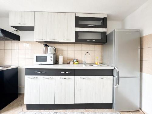 a kitchen with white cabinets and a stainless steel refrigerator at K&S Apartment Bistrik Stay in Sarajevo