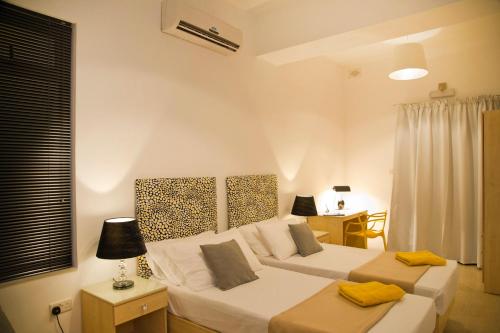 sypialnia z 2 łóżkami i biurkiem w obiekcie Maltese Balcony w mieście St. Julian’s