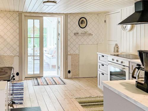 a kitchen with white appliances and a door to a patio at 5 person holiday home in HÄRADSBÄCK-By Traum in Ryd
