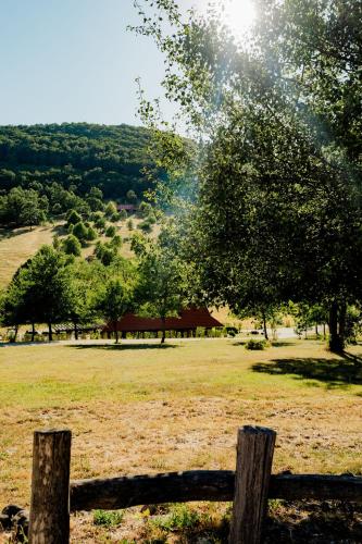 a wooden fence in a field with a tree at Farkaskútvölgy in Felsőtold
