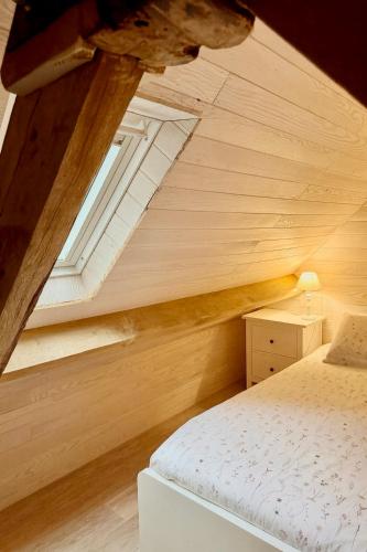 an attic bedroom with a bed and a window at Gîte du Moulin de Maître Pierre in Payrignac