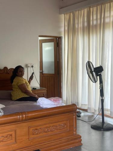 a woman sitting on a bed in a room at Nature's Hideaway in Anuradhapura